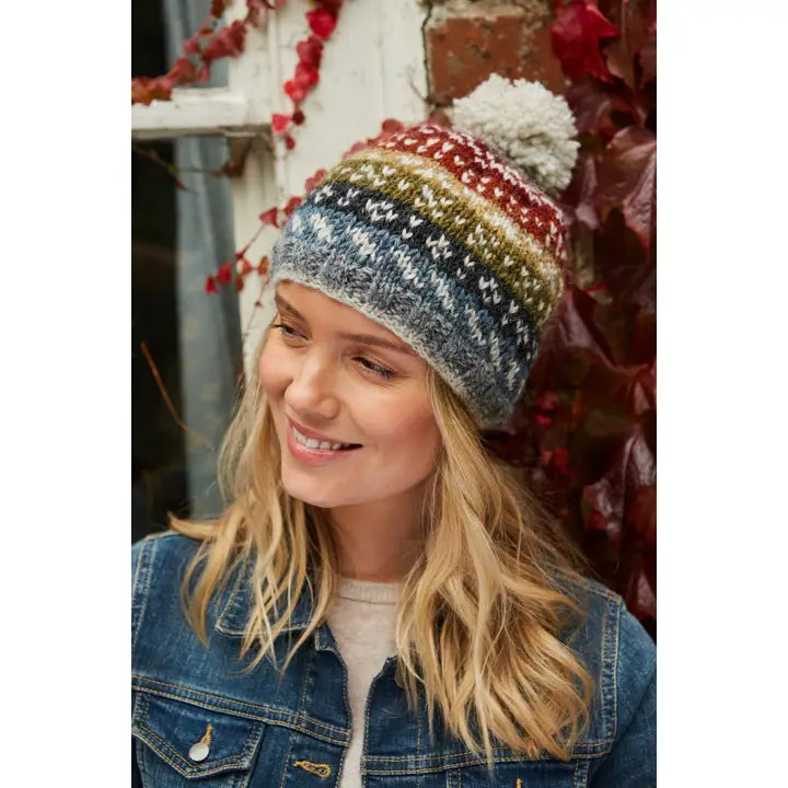 Frau trägt Helmsdale handgestrickte Fair-Isle Wollmütze mit Bommel und Stirn-Fleece, Wintermütze aus 100 % Wolle