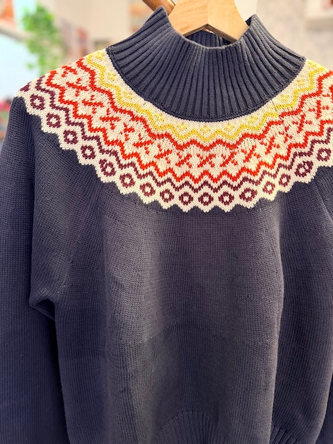 Detailaufnahme des Fair-Isle-Strickmusters und hohen Rippkragens am dunkelblauen Alana Glenbay Pullover von about betty.