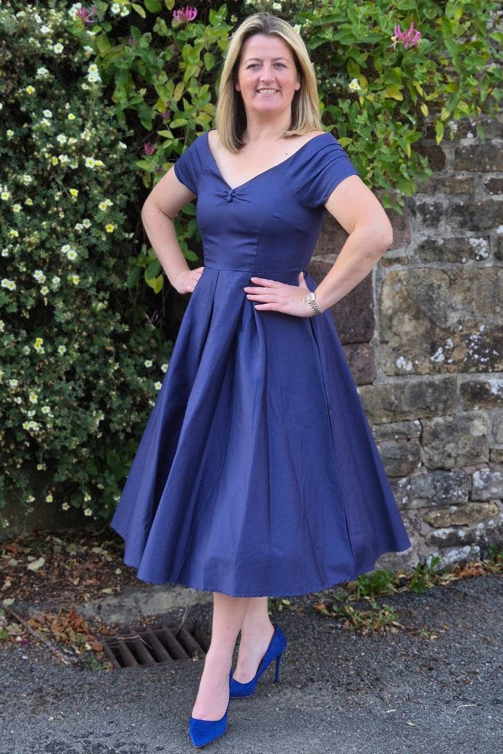 Lily 50er Jahre Kleid in Marineblau getragen mit weitem Rock und betonter Taille