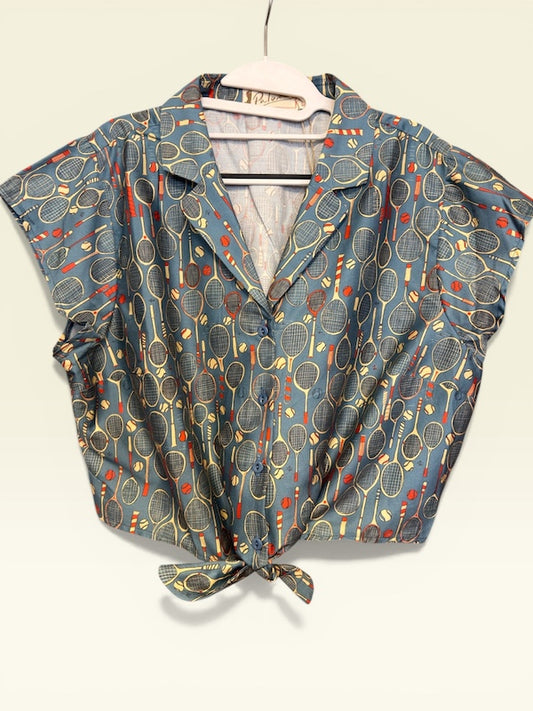 Palava Peggy Bluse im Tennis-Print aus 100% Baumwollsatin. Vintage-inspiriertes Blusentop mit Bindeband – leicht, verspielt & besonders.