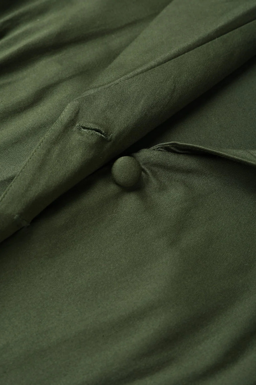 Detailaufnahme des armygrünen Baumwollstoffs und Knopfdetails am Mollie Kleid
