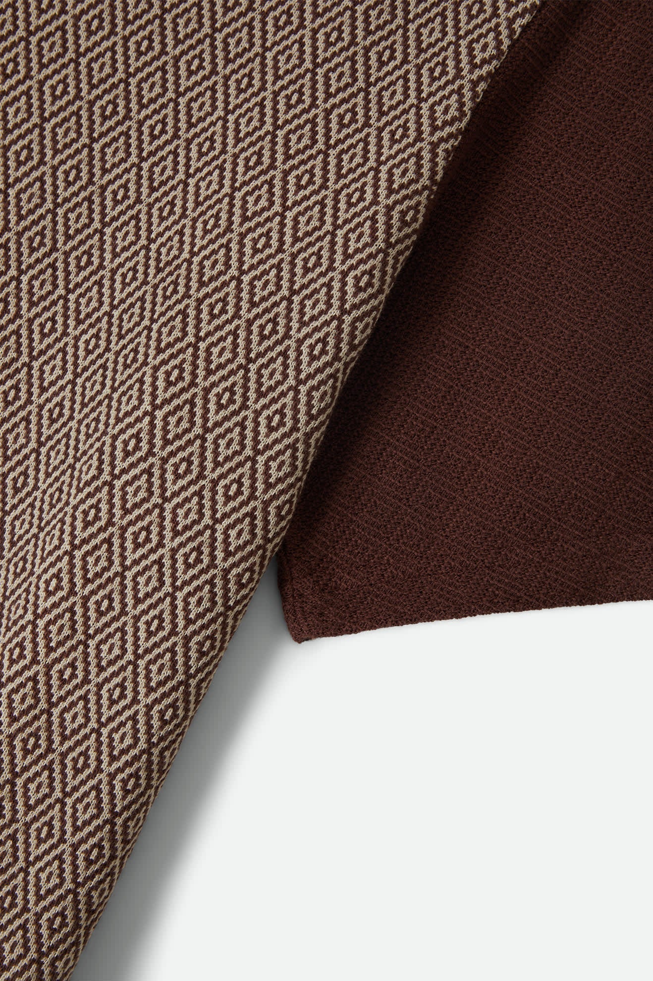 Detailaufnahme des Brixton Theo Jacquard Polo Chocolate mit Jacquard-Diamantmuster aus Baumwolle