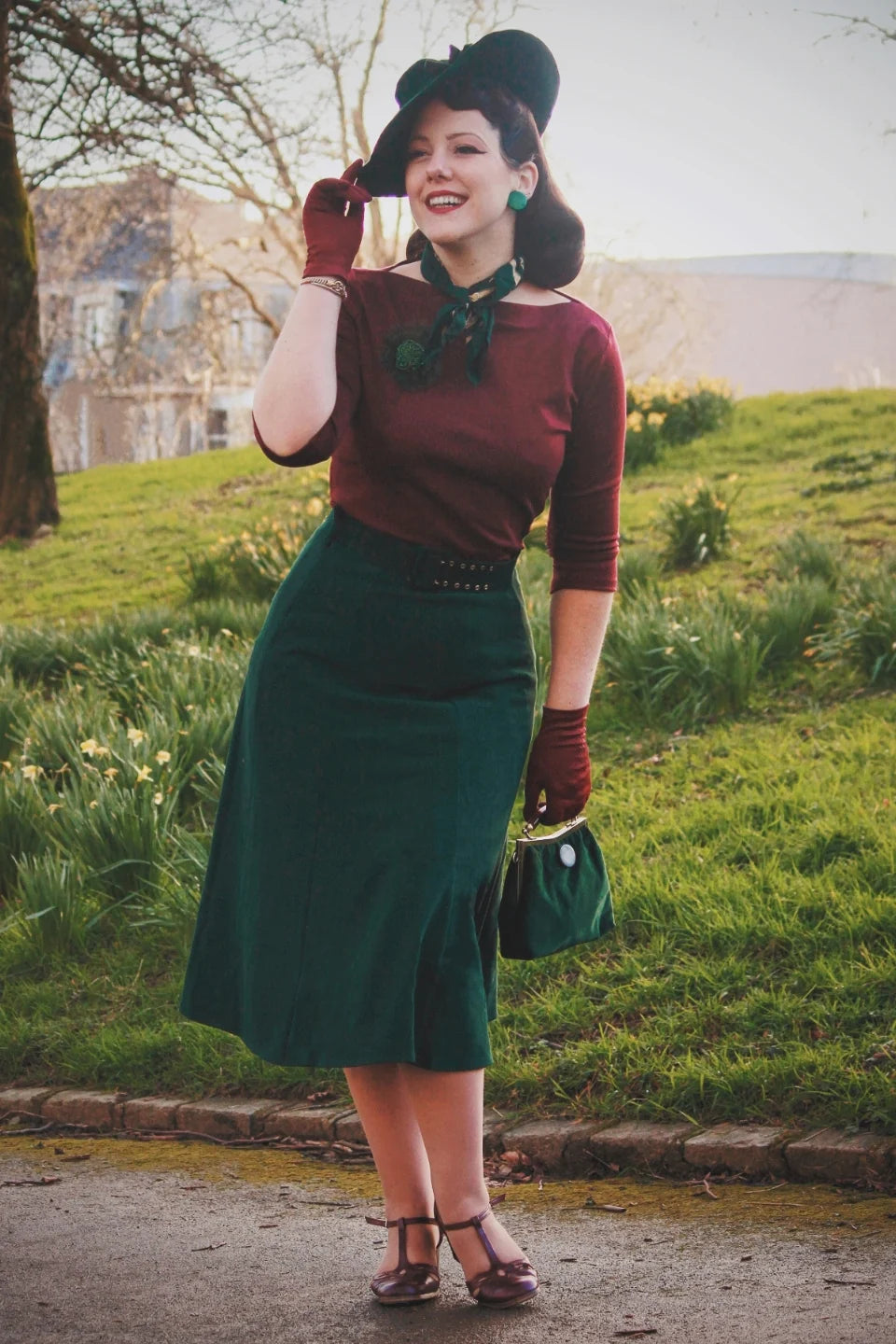 Weekend Doll Bette Midi Skirt Bottle Green getragen mit bordeauxfarbenem Oberteil im Vintage Stil
